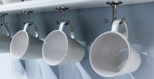 Store mugs on hooks under cabinets.