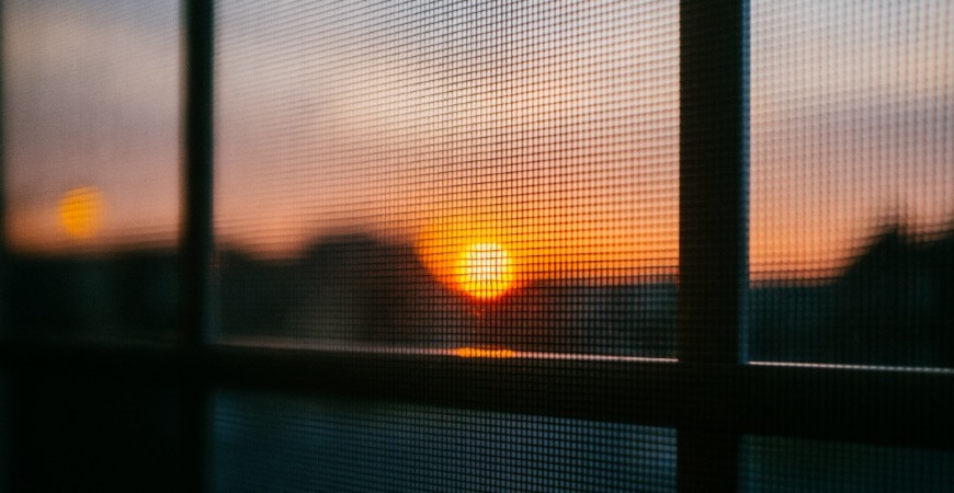 A gorgeous sunset through a window screen.